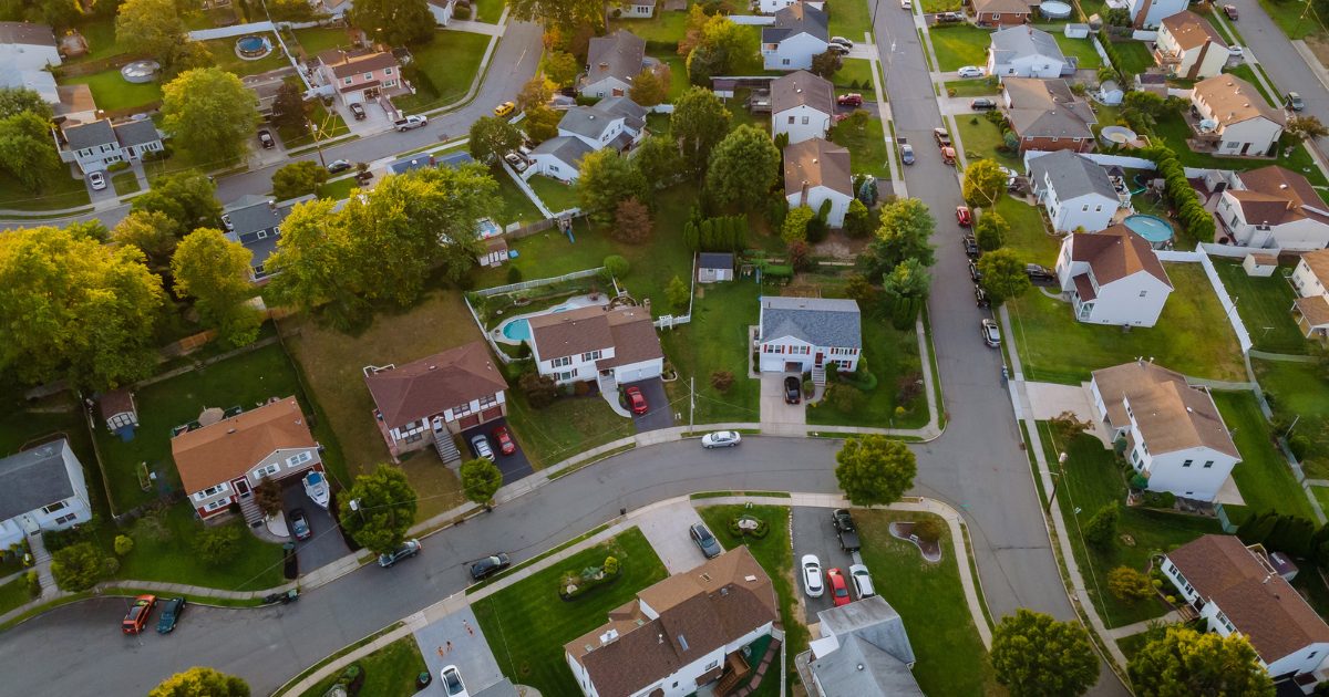 Aerial view of a tree-lined residential neighborhood with shingle-roofed homes